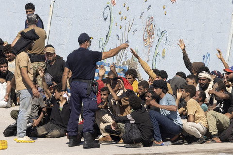 Petugas mengarahkan sejumlah migran mena... </div>
<div class=