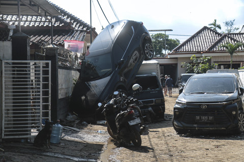Sebuah mobil menimpa mobil lainnya pascabanjir di Mataram, NTB, Senin (7/7/2025). Foto: Dhimas Budi Pratama/ANTARA FOTO