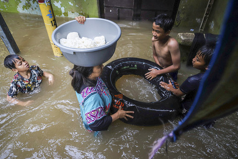 Sejumlah warga beraktivitas di tengah banjir yang melanda pemukiman padat penduduk di kawasan Kebon Pala, Kampung Melayu, Jakarta, Selasa (8/7/2025). Foto: Iqbal Firdaus/kumparan