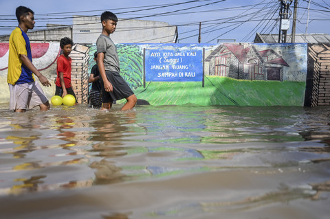 Warga melewati banjir di Perumahan Pondok Maharta, Pondok Aren, Tangerang Selatan, Banten, Selasa (8/7/2025). Foto: Rivan Awal Lingga/ANTARA FOTO