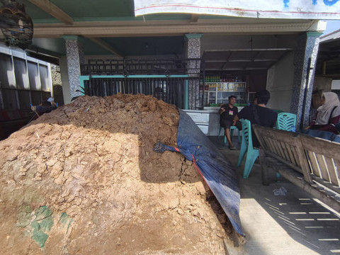 Heryatno saat menunjukan tanah kiriman dari kakek nenek yang sempat menutupi akses keluar masuk rumah. (7/7/2025). Foto: kumparan
