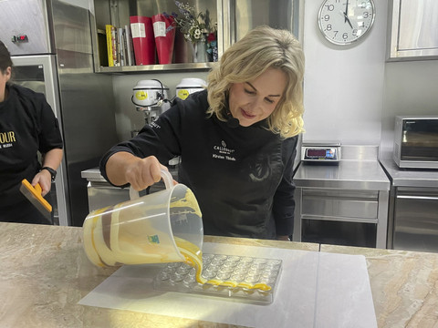 Chef Kirsten Tibbals menuangkan lapisan marbling ke cetakan cokelat. Foto: Salsha Okta Fairuz/kumparan