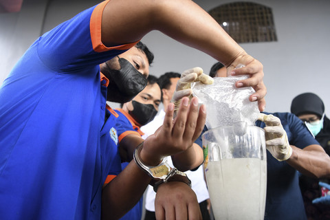 Tersangka Warga Negara Asing (WNA) asal Malaysia memasukkan narkoba jenis sabu ke dalam mesin pelumat saat pemusnahan di Badan Narkotika Nasional (BNN) Provinsi Kalimantan Timur, di Samarinda, Kamis (10/7/2025). Foto: M Risyal Hidayat/ANTARA FOTO