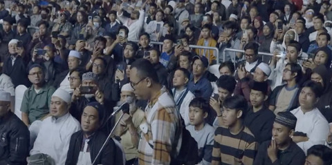 Zakir Naik membimbing pria bernama Jendra (di depan mic) membaca syahadat saat berceramah di Stadion Gajayana, Malang, Kamis (10/7/2025) malam. Foto: YouTube/@DondyTan