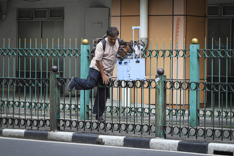 Seorang penumpang KRL melompati pagar pembatas jalan di Stasiun Cikini, Jakarta, Jumat (11/7/2025). Foto: Iqbal Firdaus/kumparan