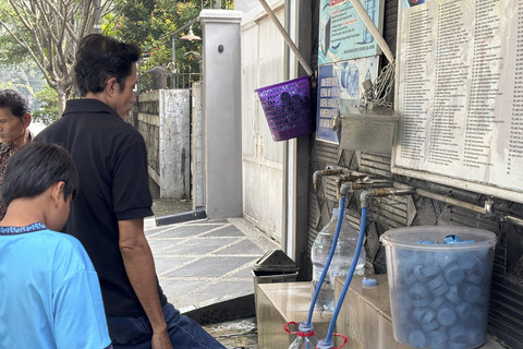 Seorang warga mengambil air minum gratis di kawasan Rawamangun, Jakarta, Sabtu (12/7/2025). Foto: Abid Raihan/kumparan