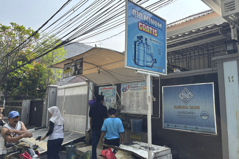 Seorang warga mengambil air minum gratis di kawasan Rawamangun, Jakarta, Sabtu (12/7/2025). Foto: Abid Raihan/kumparan