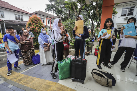 Sejumlah orang tua dan siswa membawa barang kebutuhan anaknya ke asrama saat hari pertama Sekolah Rakyat Menengah Atas 9 di Bambuapus, Jakarta Timur, Senin (14/7/2025). Foto: Jamal Ramadhan/kumparan