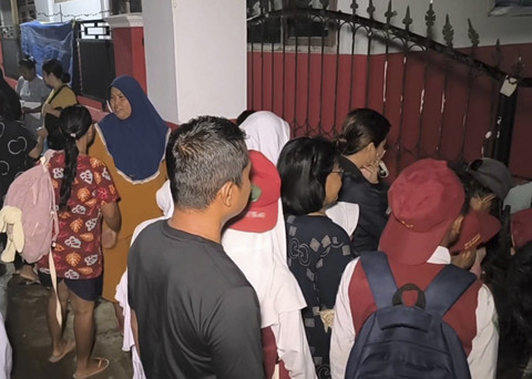 Orang tua murid dan murid saat hendak masuk ke sekolah menunggu penjaga sekolah membuka gerbang di SD Negeri 4 Kedokanagung, Kecamatan Kedokan Bunder, Kabupaten Indramayu, Senin (14/7/2025). Foto: kumparan