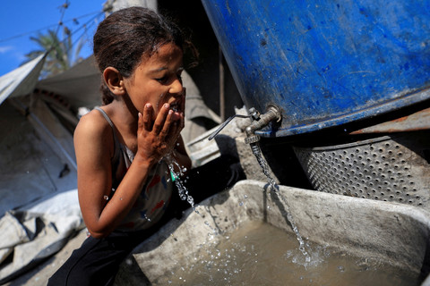 Seorang anak pengungsi Palestina mencuci wajahnya di tengah kekurangan air di Kota Gaza, Senin (14/7/2025). Foto: Dawoud Abu Alkas/REUTERS