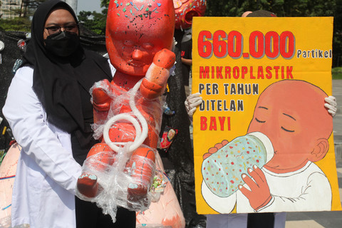 Sejumlah aktivis lingkungan membentangkan poster dan replika bayi saat aksi Plastic Free July 2025 di Surabaya, Jawa Timur, Rabu (16/7/2025). Foto: ANTARA FOTO/Didik Suhartono