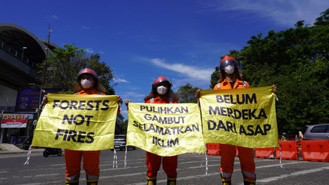 3 anggota ISSPA yang berdiri di depan Jembatan Ampera untuk berkampanye isu kabut asap/Anyelir.