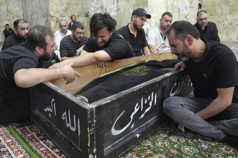 Sejumlah pelayat menangis di dekat peti jenazah korban kebakaran mal di al-Kut, Irak, Kamis (17/7/2025). Foto: QASSEM AL-KAABI/AFP
