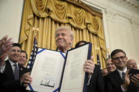 Presiden AS Donald Trump menampilkan Undang-Undang GENIUS (Mendu dan Menetapkan Inovasi Nasional untuk Undang-Undang Stablecoin AS) usai ditandangani di Ruang Timur Gedung Putih, Washington, DC, Amerika Serikat, Jumat (18/7/2025). Foto: Brendan Smialowski/AFP