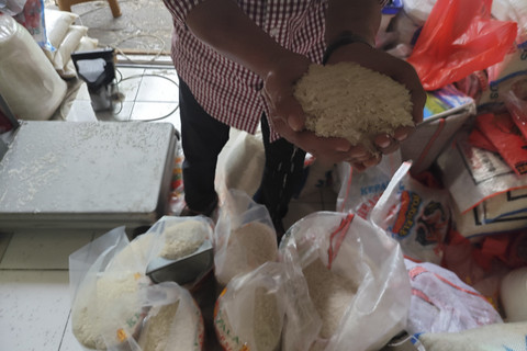 Pekerja menunjukkan beras yang dijual di Pasar Induk Beras Cipinang (PIBC) Jakarta Timur, Sabtu (19/7/2025). Foto: Widya Islamiati/kumparan