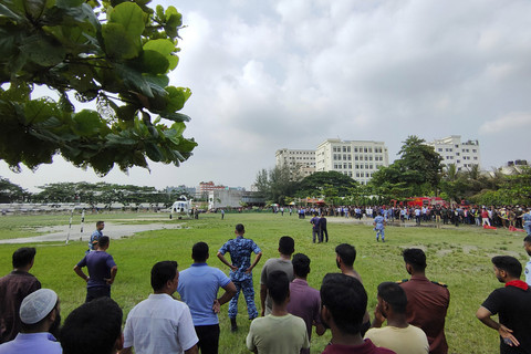 Orang-orang berkumpul di lokasi jatuhnya pesawat latih Angkatan Udara Bangladesh di Dhaka, Bangladesh, Senin (21/7/2025). Foto: Mahmud Hossain Opu/AP Photo