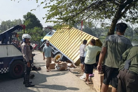 Sebuah truk box bermuatan buku pelajaran sekolah terperosok ke Setu Jatijajar, Kelurahan Jatijajar, Kecamatan Tapos, Kota Depok, Selasa (22/7/2025). Foto: kumparan