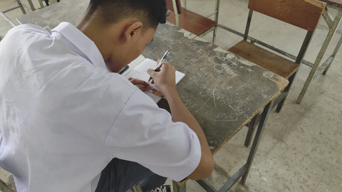 Seorang murid kelas sepuluh sedang belajar sendirian di SMA Taman Siswa, Kota Bandung, Rabu (23/7/2025). Foto: Alya Zahra/kumparan