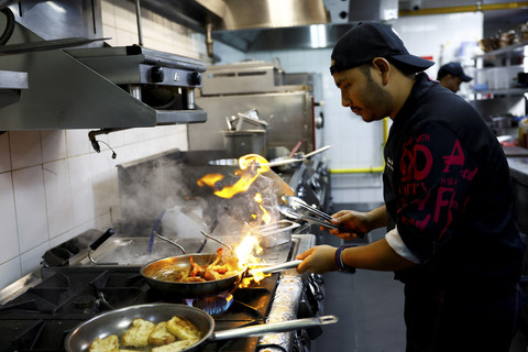 Chef Khimraj Nepal menyiapkan hidangan menggunakan resep dari "Aiman", koki AI, di Restoran Trove di Dubai, Uni Emirat Arab, Selasa (8/7/2025). Foto: Rula Rouhana/REUTERS