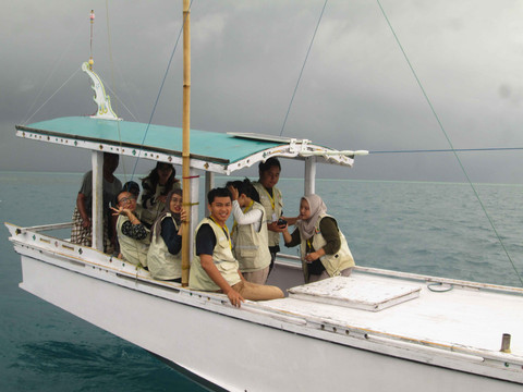 Mahasiswa KKN PPM UGM Baweanesia 2025 saat mengikuti prosesi larung hasil bumi di laut (Dokumentasi Tim KKN PPM UGM Baweanesia 2025