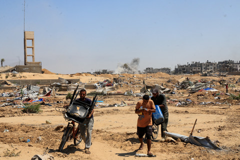 Pengungsi Palestina berjalan sambil membawa barang-barang mereka setelah operasi militer Israel di Deir Al-Balah, Jalur Gaza tengah, Selasa (22/7/2025). Foto: Hatem Khaled/REUTERS