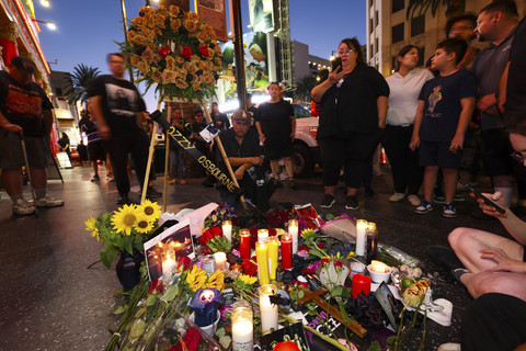 Sejumlah penggemar meletakkan bunga-bunga di bintang Ozzy Ousbourne di Walk of Fame Hollywood, Los Angeles Amerika Serikat, Selasa (22/7/2025). Foto: Patrick T. Fallon/AFP