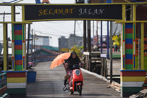 Warga mengendarai sepeda listrik di Desa Muara Enggelam, Muara Wis, Kutai Kartanegara, Kalimantan Timur, Selasa (22/7/2025). Foto: M Risyal Hidayat/ANTARA FOTO