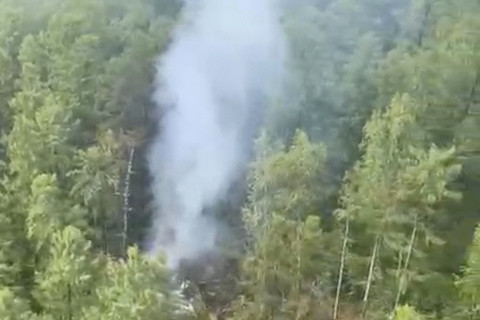 Asap mengepul di lokasi jatuhnya pesawat penumpang Angara Airlines An-24 di dekat Tynda di Wilayah Amur, Rusia, Kamis (24/7/2025). Foto: Federal Air Transport Agency/Via Reuters