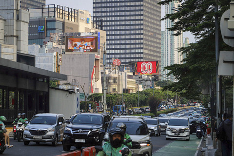 Sejumlah kendaraan melintas di dekat Videotron yang menampilkan logo HUT RI ke-80 di kawasan Jalan Sudirman, Jakarta, Kamis (24/7/2025). Foto: Iqbal Firdaus/kumparan