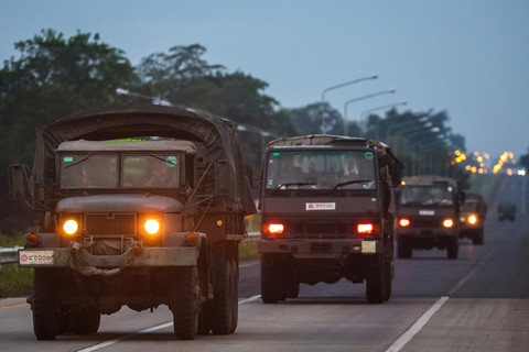 Kendaraan militer melaju di sepanjang jalan di... </div>
<div class=