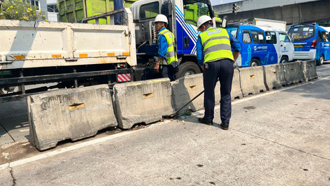 Petugas memperbaiki pembatas jalan di tempat kejadian perkara (TKP) setelah kecelakaan beruntun di Jalan Perintis Kemerdekaan, Jakarta Timur, Jumat (25/7). Foto: Nasywa Athifah/kumparan