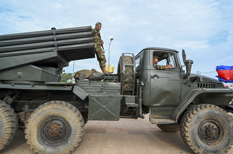 Seorang prajurit Kamboja berdiri di atas truk yang mengangkut peluncur roket BM-21 buatan Rusia melintas saat konflik Thailand dan Kamboja di Provinsi Oddar Meanchey, Kamboja, Jumat (25/7/2025). Foto: Tang Chhin Sothy/AFP