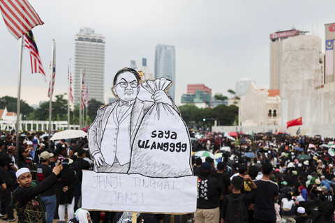 Pengunjuk rasa membentangkan poster saat demonstrasi menuntut Perdana Menteri Malaysia Anwar Ibrahim untuk mundur di Kuala Lumpur, Malaysia, Sabtu (26/7/2025). Foto: Hasnoor Hussain/Reuters