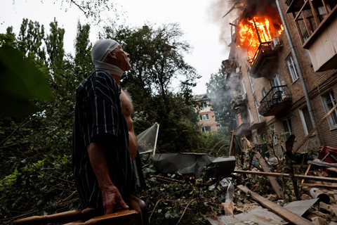 Seorang warga yang terluka berdiri di luar rumahnya yang rusak akibat serangan rudal dan pesawat tak berawak Rusia, di tengah serangan Rusia terhadap Ukraina, di Kyiv, Ukraina, 31 Juli 2025. Foto: REUTERS/Thomas Peter