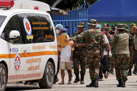 Seorang prajurit Kamboja (tengah), yang ditangkap oleh militer Thailand, berjalan menuju ambulans setelah dikembalikan ke Kamboja melalui pos pemeriksaan perbatasan O'Smach di Provinsi Oddar Meanchey, Jumat (1/8/2025). Foto: Stringer/AFP