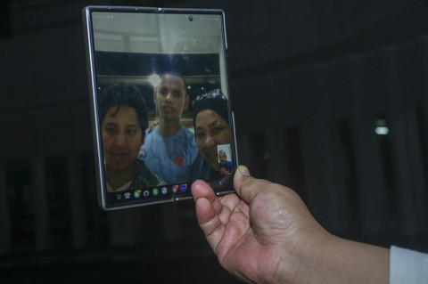 Melepas rindu dengan sang ayah: Perenang tuna netra asal DKI Jakarta, Bernama Iasadewa Satrianya Aji bersama ibu dan saudaranya melakukan panggilan video dengan ayahnya yang bertugas sebagai anggota TNI di Papua. Foto: Jasmine Nadhya Thanaya/ANTARA FOTO