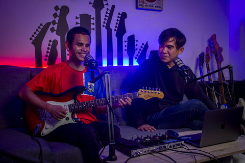 Bermain gitar: Perenang tuna netra asal DKI Jakarta, Bernama Iasadewa Satrianya Aji, menunjukkan kebolehannya dalam bermain gitar dalam salah satu acara podcast salah satu influencer musik. Foto: Jasmine Nadhya Thanaya/ANTARA FOTO
