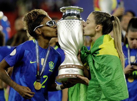 Luany dan Giovana dari Brasil merayakan kemenangan dengan trofi setelah menjuarai Copa America Femenina 2025 di Estadio Rodrigo Paz Delgado, Quito, Ekuador, Minggu (3/8/2025). Foto: Cristina Vega/REUTERS 