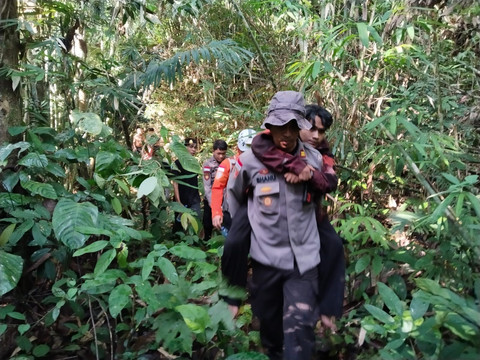 Personel Polres Bengkayang menggendong salah satu pendaki saat evakuasi dari Gunung Bawang. Foto: Dok. Polres Bengkayang 