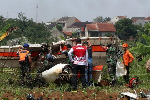 Petugas Basarnas bersama prajurit TNI AU mengevakuasi bangkai pesawat latih sipil Microlight Fixedwing Quicksilver GT500 dengan register PK-S126 yang jatuh di perkebunan warga, TPU Astana, Ciampea, Kabupaten Bogor, Jawa Barat, Minggu (3/8/2025). Foto: Fadli/ANTARA FOTO