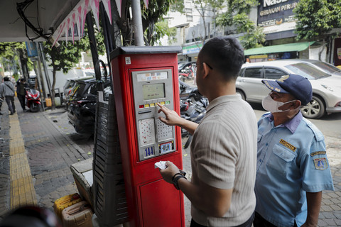 Petugas membantu pengguna parkir mengoperasikan mesin parkir di Jalan Sabang, Jakarta, Senin (4/8/2025). Foto: Jamal Ramadhan/kumparan