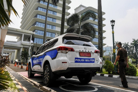 Pegawai Kejagung melintas di samping mobil Polisi Militer yang terparkir di Gedung Kejaksaan Agung, Jakarta, Senin (27/5/2024). Foto: Galih Pradipta/ANTARA FOTO