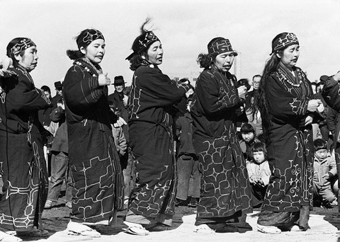 Sekelompok perempuan Ainu menampilkan tarian tradisional, sekitar tahun 1950. Orang-orang Ainu tidak memiliki bahasa tertulis, sedangkan bahasa lisan mereka diyakini tidak berhubungan dengan bahasa lain yang dikenal luas.