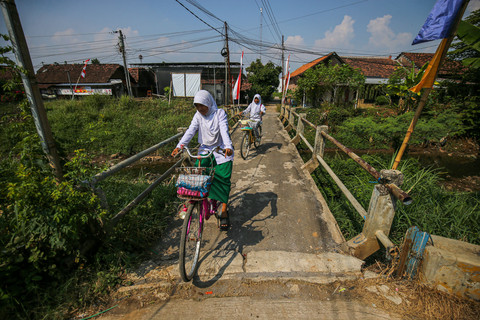 Anak-anak Kesambi bersepeda pulang dari sekolah. Mereka bisa tumbuh lebih baik bila lingkungan desa lebih sehat. Foto: Aditia Noviansyah/kumparan