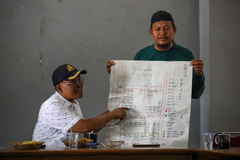 Kepala Desa, Mokhamad Masri (kiri) dan Ketua KSM Tirta Saras Adi Prasetio (Doyok) menjelaskan peta wilayah penerima manfaat pembuatan septic tank pada program sanitasi yang diberikan oleh Djarum Foundation di Desa Kesambi, Kudus, Jawa Tengah, Selasa (5/8/2025). Foto: Aditia Noviansyah/kumparan