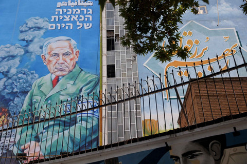 Karikatur Perdana Menteri Israel Benjamin Netanyahu yang dimiripkan dengan Hitler,dipajang di sebuah gedung di Teheran, Iran, Minggu (10/8/2025). Foto: Majid Asgaripour/Wana News Agency via Reuters