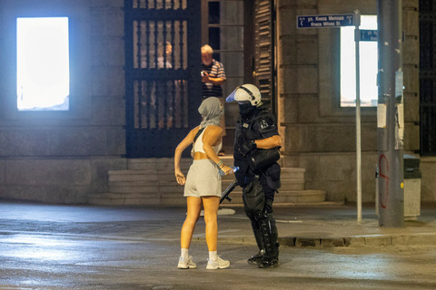 Polisi mengamankan pengunjuk rasa saat demo pendukung partai berkuasa dan pengunjuk rasa anti-pemerintah di Beograd, Serbia, Rabu (13/8/2025). Foto: Djordje Kojadinovic/REUTERS