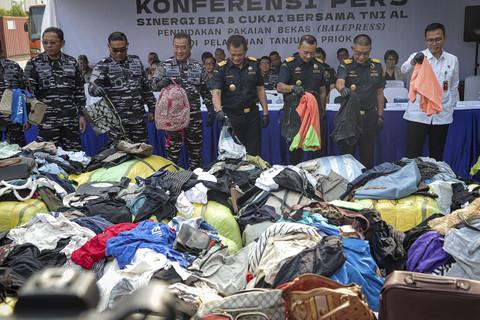 Panglima Komando Armada Republik Indonesia (Pangkoarmada RI) Laksamana Madya TNI Denih Hendrata bersama Dirjen Bea Cukai Djaka Budi Utama menunjukan barang bukti sitaan pakaian bekas di Pelabuhan Tanjung Priok, Jakarta, Rabu (14/8/2025). Foto: Iqbal Firdaus/kumparan