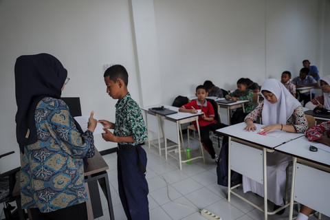 Kegiatan Mengajar: Galih, meminta penilaian guru saat belajar bahasa Inggris di Sekolah Rakyat Menengah Pertama (SRMP) 6 Jakarta. Foto: Jamal Ramadhan/kumparan