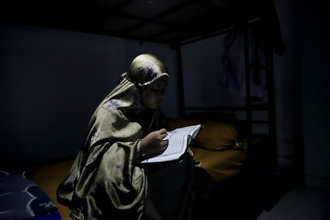 Mengaji: Siswi, Kamila, mengaji menjelang tidur di kamar asrama Sekolah Rakyat Menengah Pertama (SRMP) 6 Jakarta. Foto: Jamal Ramadhan/kumparan